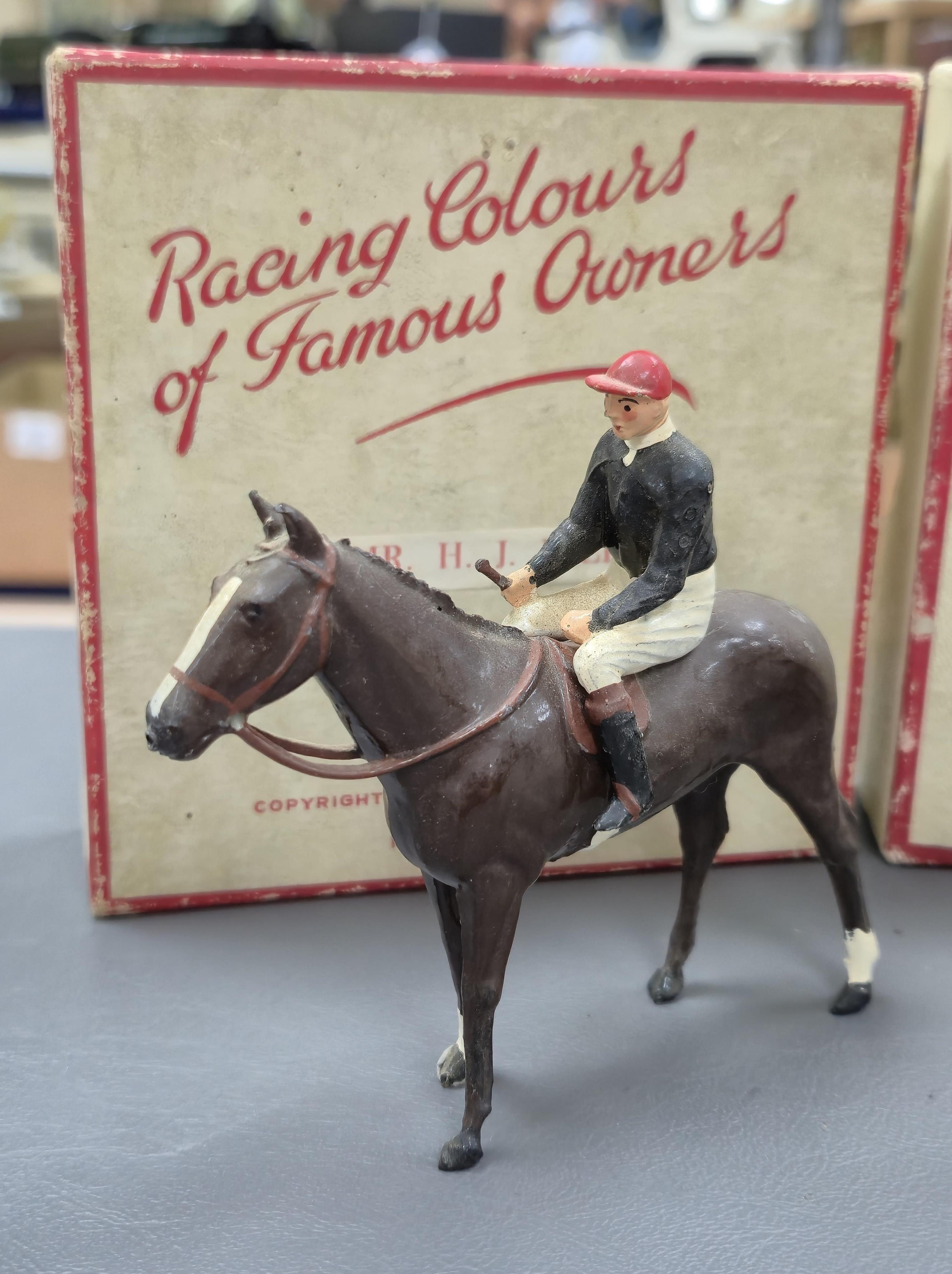 Two boxed Britains Racing Colours of Famous Owners series lead mounted figures; Lord Derby - rider in black jersey with a white cap on a brown horse, and Mr. H. J. Joel - rider in black jersey with red cap on a dark brow